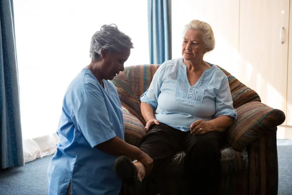 Sjuksköterska att hjälpa senior kvinna i stretching benen — Stockfoto