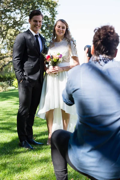 Photographer taking photo of newly married couple — Stock Photo, Image