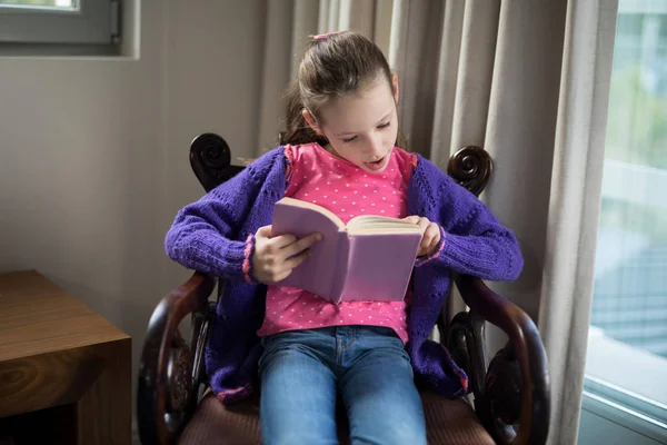 女の子読書本上の椅子 — ストック写真