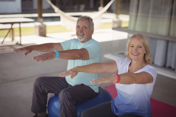 Sorrindo casal sênior exercitando em bola de exercício — Fotografia de Stock