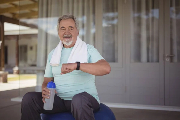 Senior kontrolliert Zeit auf Armbanduhr — Stockfoto