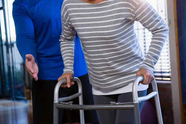 Physiotherapeut hilft Patient beim Gehen — Stockfoto