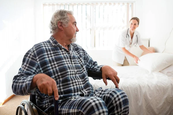 Senior man looking at doctor — Stock Photo, Image