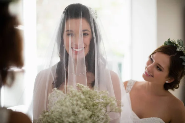 Noiva de pé com buquê de flores em casa — Fotografia de Stock