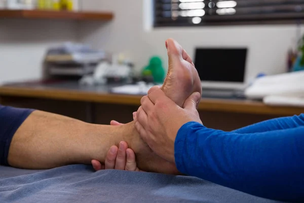 Fisioterapeuta dando massagem nos pés ao paciente — Fotografia de Stock