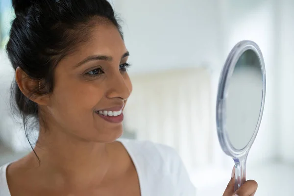 Mujer sonriente sosteniendo espejo de mano — Foto de Stock