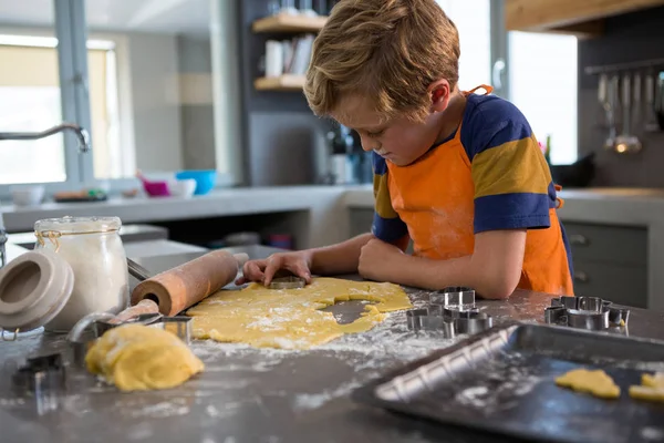 Boy making shapes from pastry cutter — Stock Photo, Image