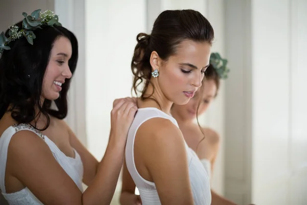 Bridesmaid assisting bride to dress — Stock Photo, Image