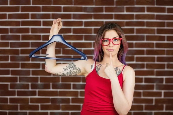 Confused woman holding hanger — Stock Photo, Image