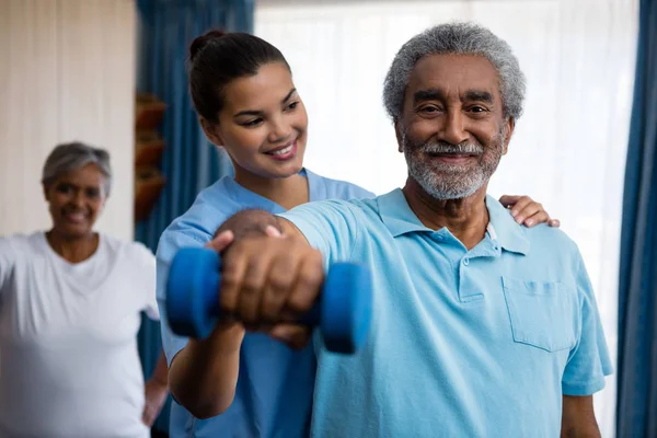 Sjuksköterska vägledande senior man utövar — Stockfoto