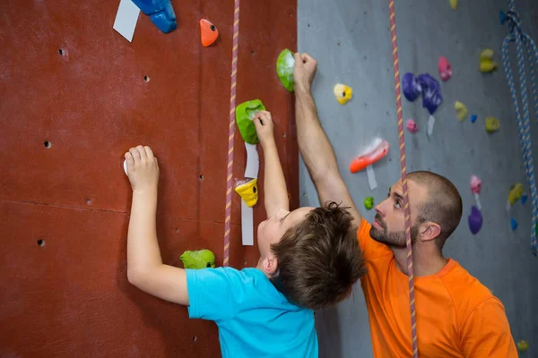 Treinador assistindo menino na escalada — Fotografia de Stock