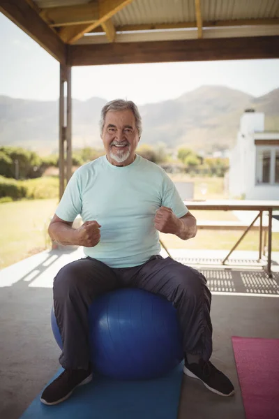 Starší muž, sedící na fitness míč — Stock fotografie