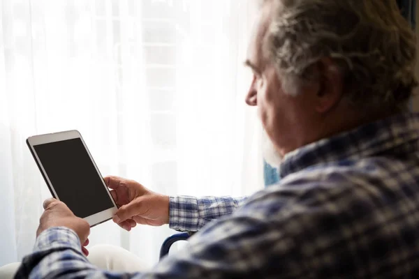 Uomo anziano utilizzando tablet in casa di cura — Foto Stock