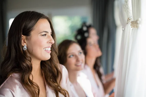 Mulheres sorridentes olhando para o vestido de noiva — Fotografia de Stock