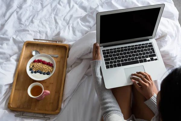 Mulher com laptop pelo café da manhã na cama — Fotografia de Stock