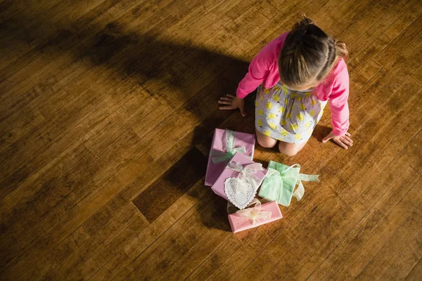 Ragazza seduta con scatole regalo sul pavimento — Foto Stock