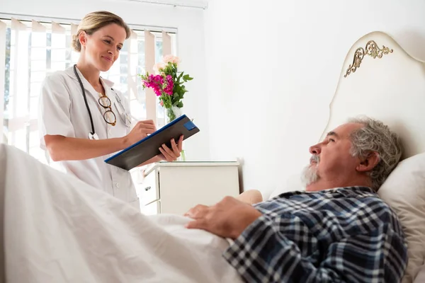 Médico examinando paciente masculino en hogar de ancianos —  Fotos de Stock