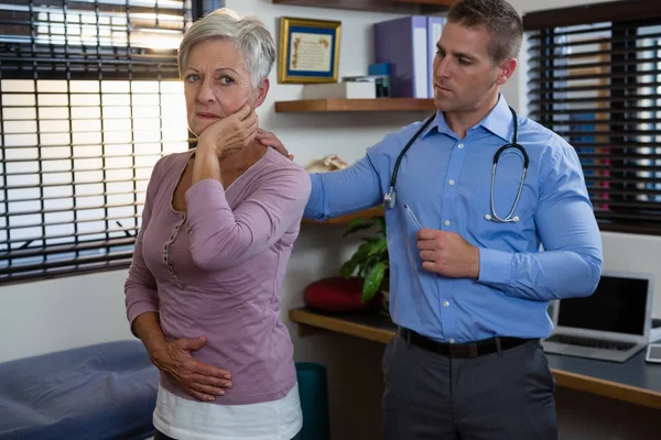 Fisioterapeuta examinando el cuello de un paciente — Foto de Stock