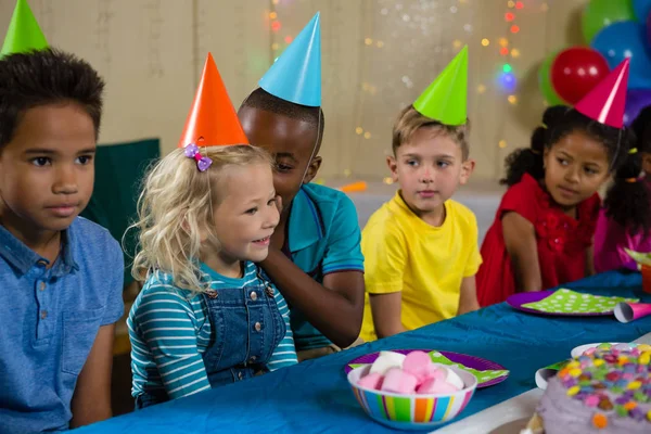 Freunde sehen Jungen an, der Mädchen zuflüstert — Stockfoto