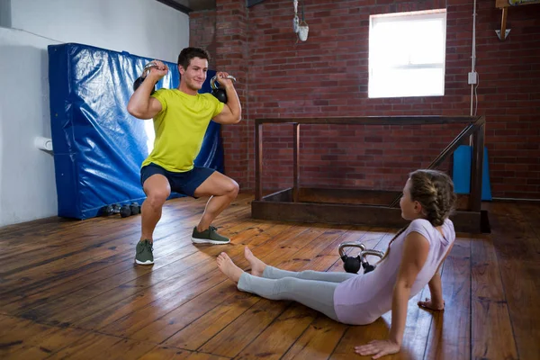 Trainer tienermeisje bijstaan in de uitoefening — Stockfoto