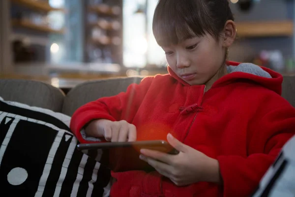 Lány segítségével digitális tábla kanapéval — Stock Fotó