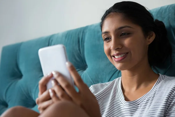 Glimlachende vrouw die telefoon gebruikt — Stockfoto