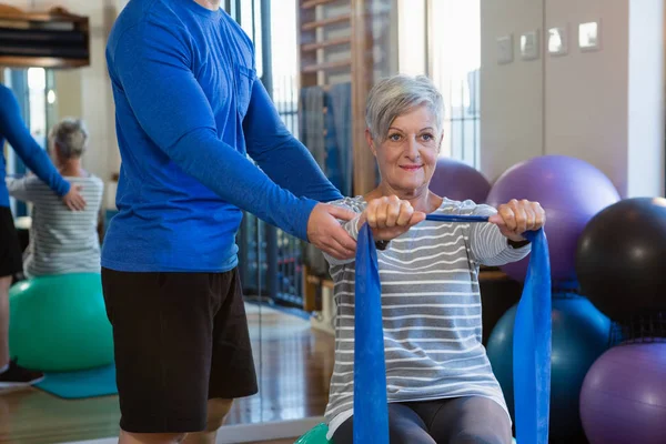 Fisioterapista che assiste la donna anziana nello stretching — Foto Stock