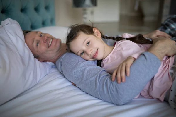 Otec a dcera ležela na posteli v ložnici — Stock fotografie