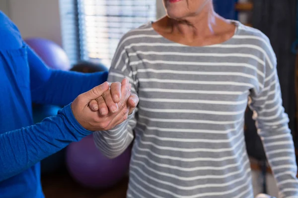 Physiotherapeut hält Hand der Seniorin — Stockfoto