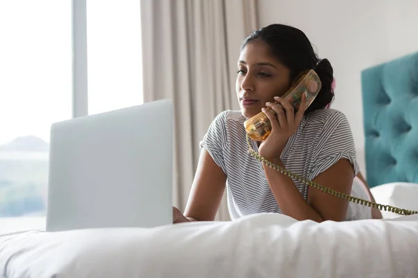 Vrouw praten op telefoon tijdens het gebruik van Laptop — Stockfoto