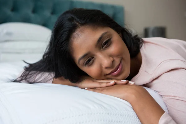 Eftertänksam kvinna vilar på sängen — Stockfoto