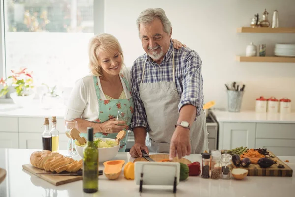 Senior couple preparing meal in kitchen — Stock Photo, Image