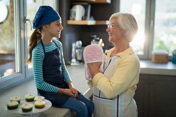 Oma en kleindochter met oven handschoenen — Stockfoto