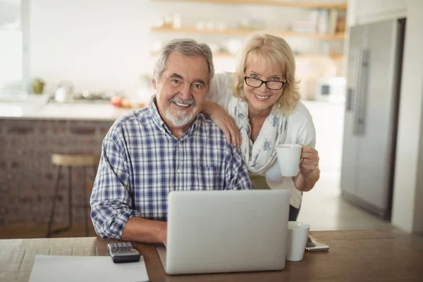 Senior couple using laptop at home