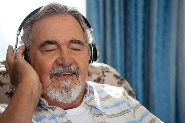 Hombre escuchando música a través de auriculares —  Fotos de Stock