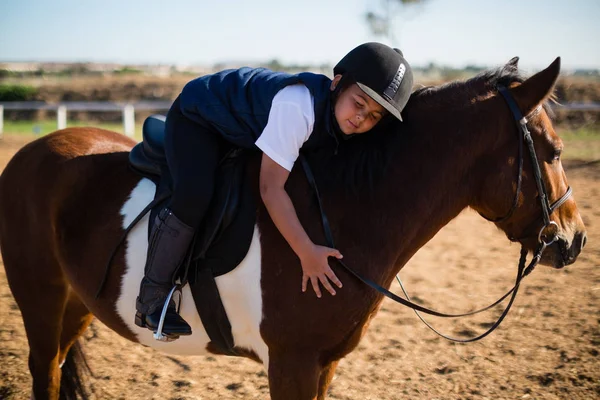 Menino abraçando cavalo no rancho — Fotografia de Stock