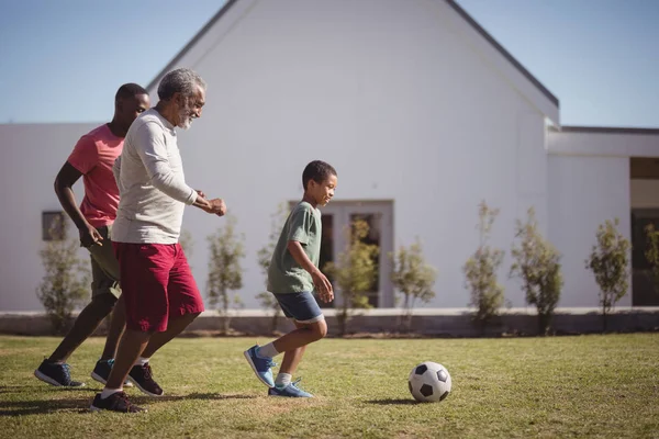 Menino jogando futebol com pai e neto — Fotografia de Stock