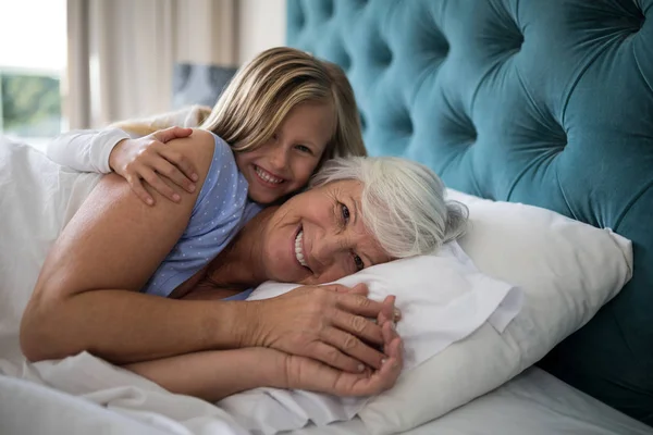 Granddaughter and grandmother lying together — Stock Photo, Image