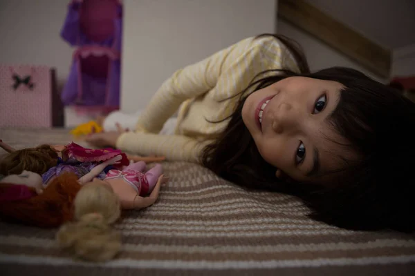 Retrato de chica con juguetes en la cama — Foto de Stock