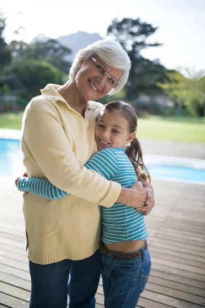 Neta e avó abraçando perto da piscina — Fotografia de Stock