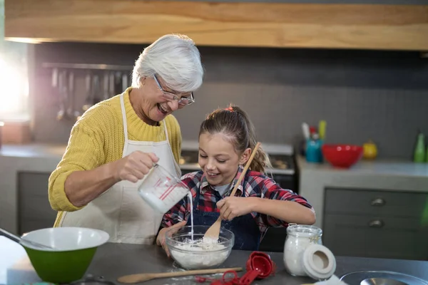 Abuela y nieta mezclando harina — Foto de Stock