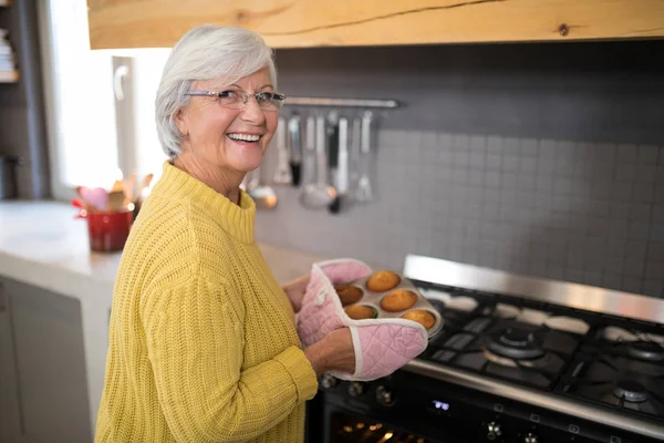 Äldre kvinnor hålla nybakade muffins — Stockfoto