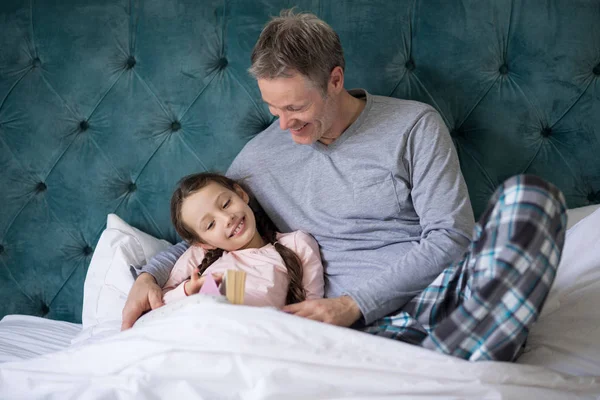Baba ve kızı yatakta kitap okumak — Stok fotoğraf