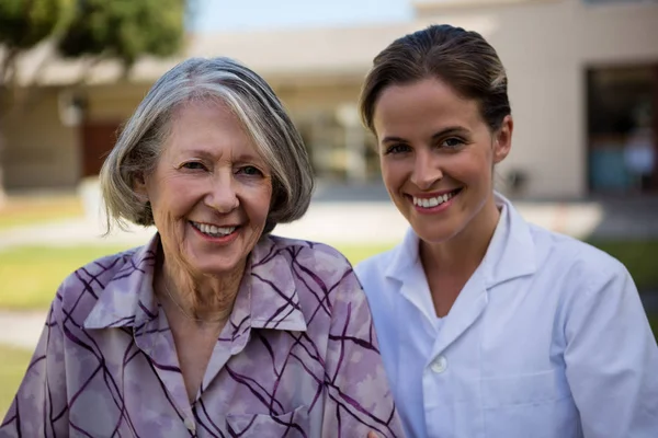 Médico sorridente e mulher idosa — Fotografia de Stock