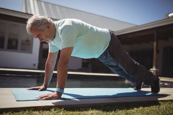 Homem sênior fazendo push-up perto da piscina — Fotografia de Stock