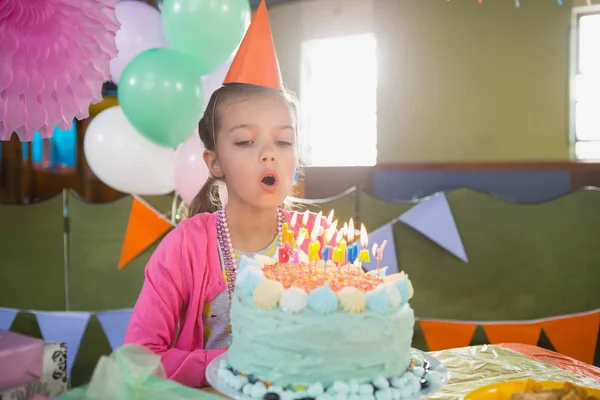Chica soplando velas en pastel de cumpleaños —  Fotos de Stock