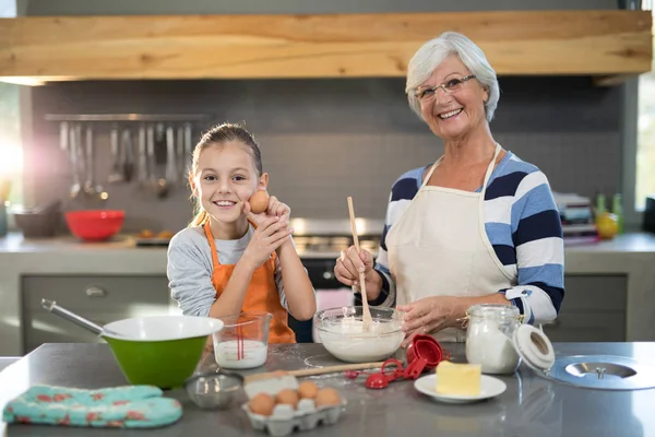 Granddaughter holding eggs and grandmother smiling — Stock Photo, Image