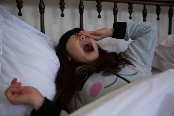 Menina bocejando na cama — Fotografia de Stock
