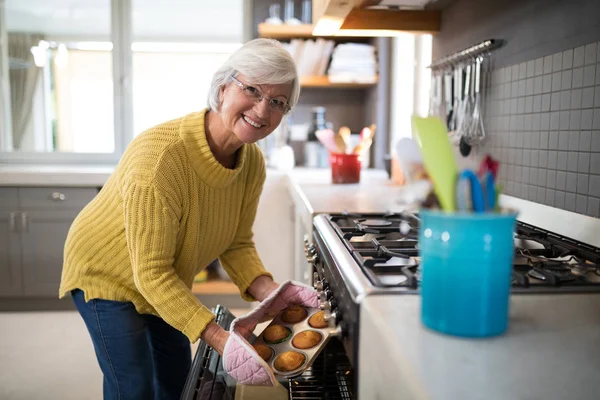 Kvinna med bricka med färska kakor ur ugnen — Stockfoto