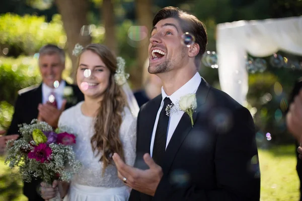 Casal brincando com bolhas no parque — Fotografia de Stock